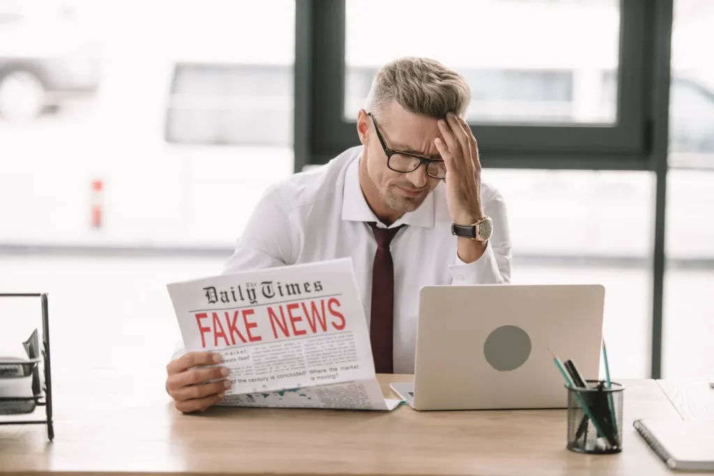 Stressed person working on laptop with negative news
