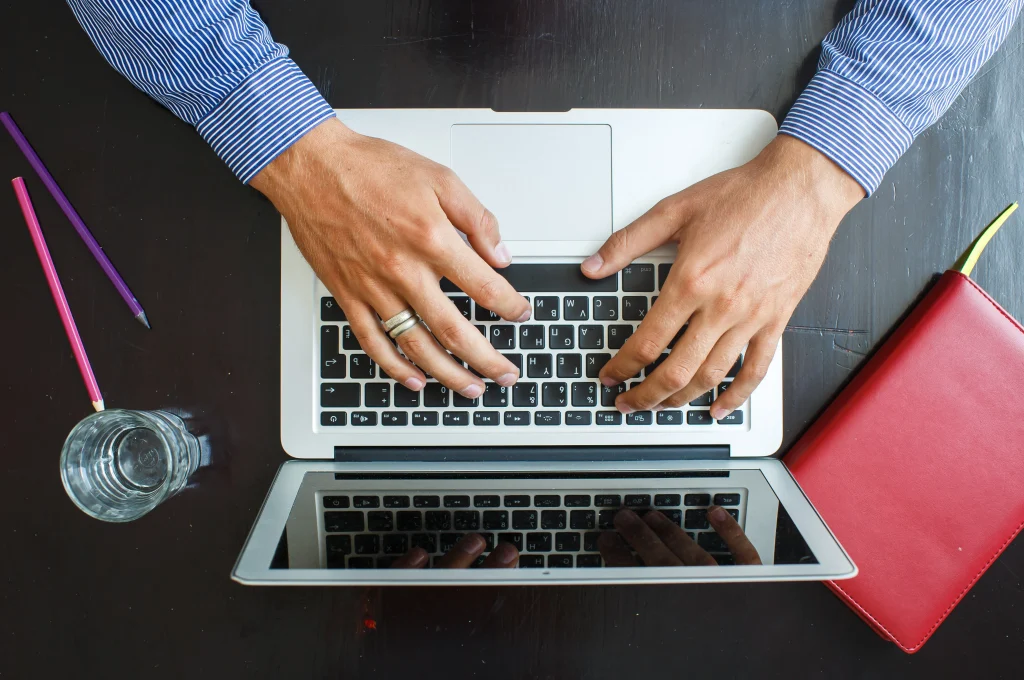 cropped-image-young-man-working-his-laptop-home-top-view-business-man-hands-busy-using-laptop-office-desk
