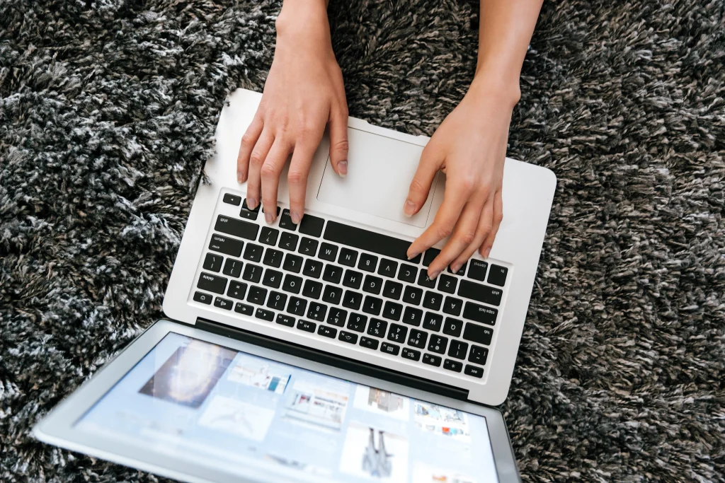 laptop-used-by-woman-hands-carpet